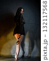 Woman in lingerie holds handcuffs looking over shoulder 132117568