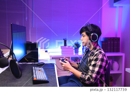Focused gamer playing video game at night time Focused gamer playing video game at night time 132117739