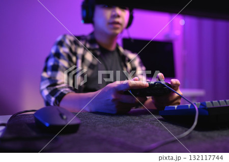 Closeup man playing video game at night with headset and neon RGB lighting 132117744