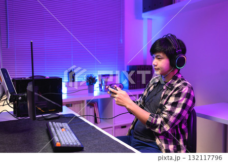 Focused gamer playing video game at night time Focused gamer playing video game at night time 132117796