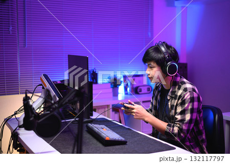Focused gamer playing video game at night time Focused gamer playing video game at night time 132117797