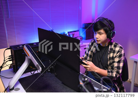 Focused gamer playing video game at night time Focused gamer playing video game at night time 132117799