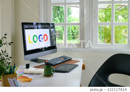 Creative woman designing logo sketches on notebook with color samples and tools in bright modern workspace Creative woman designing logo sketches on notebook with color samples and tools in bright modern workspace 132117814