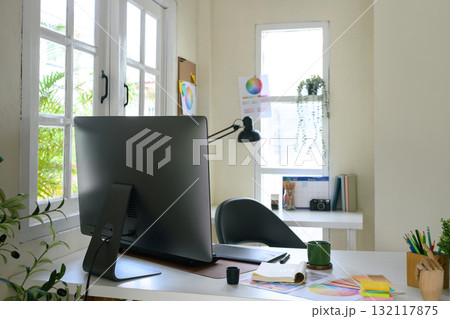 Top view of creative workspace with color palette, digital tablet, and notebook sketching logo design on clean white desk Top view of creative workspace with color palette, digital tablet, and notebook sketching logo design on clean white desk 132117875