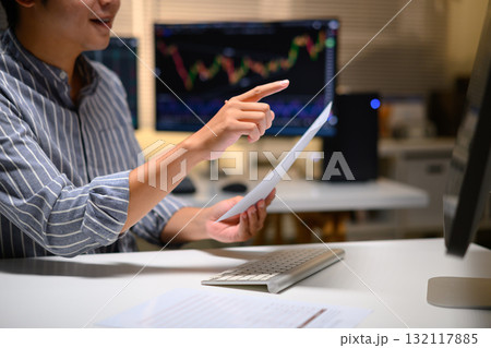 Cropped shot young man trader analyzing financial charts on computer at night, focused on investment strategy 132117885