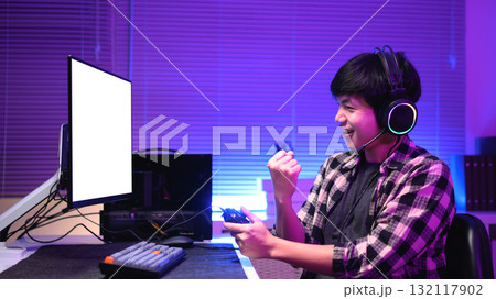 Excited gamer celebrating victory after winning video game and empty screen computer 132117902