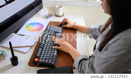Graphic designer working on computer with color palette and digital tablet in modern workspace Graphic designer working on computer with color palette and digital tablet in modern workspace 132117955
