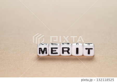 木の板の上に置かれたMERITのアルファベットビーズ 132118525