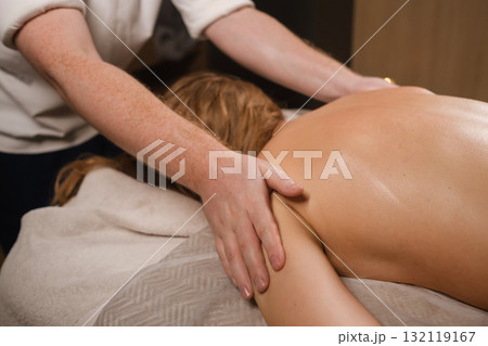 Relaxing massage session in a serene spa environment focusing on tension relief and wellness during a peaceful afternoon 132119167
