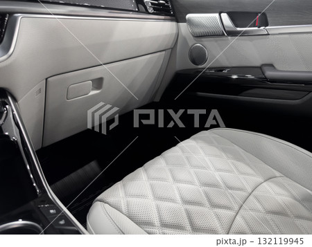 Car white leather interior. Part of white leather car seat details with white stitching. Interior of prestige car. Comfortable perforated leather seats. Perforated leather. Car white leather interior. Part of white leather car seat details with white stitching. Interior of prestige car. Comfortable perforated leather seats. Perforated leather. 132119945