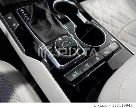 Automatic gear stick of a modern car. Modern car interior details. Close up view. Car inside. Automatic transmission lever shift. White leather interior with stitching 132119948