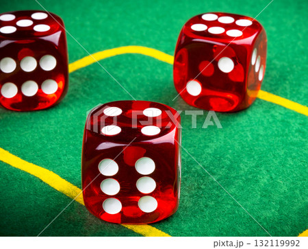 Playing dice on a green gaming table. Playing a game with dice. Red casino dice rolls. 132119992