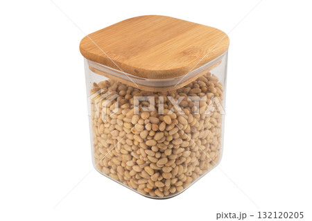 Cedar nuts in glass jar isolated on white background. Transparent glass package of pine nuts. Top view 132120205