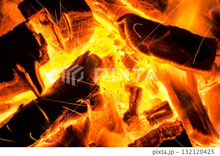 Abstract background with Burning firewood in the fireplace close up, BBQ fire, Sparking charcoal background. Spark of bonfire. 132120425