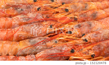 Raw frozen shrimp background. Pile of frozen shrimps. Close-up of frozen shrimps. A lot of royal shrimp macro shot. Red giant argentine shrimp texture background. Large tiger shrimp Raw frozen shrimp background. Pile of frozen shrimps. Close-up of frozen shrimps. A lot of royal shrimp macro shot. Red giant argentine shrimp texture background. Large tiger shrimp 132120478