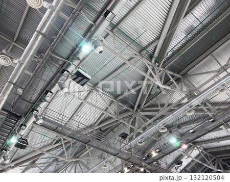 Lights and ventilation system in long line on ceiling of the industrial building. Exhibition Hall. Ceiling factory construction Lights and ventilation system in long line on ceiling of the industrial building. Exhibition Hall. Ceiling factory construction 132120504