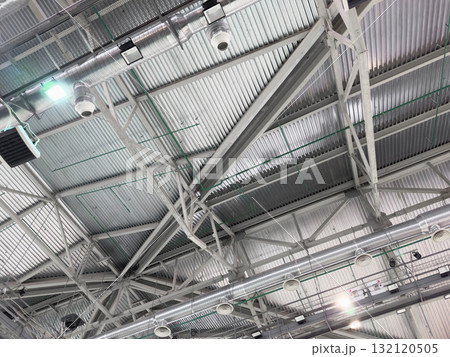 Lights and ventilation system in long line on ceiling of the industrial building. Exhibition Hall. Ceiling factory construction Lights and ventilation system in long line on ceiling of the industrial building. Exhibition Hall. Ceiling factory construction 132120505