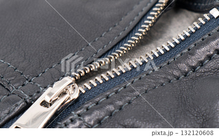 Macro shot of zipper on black leather texture background with stitching. Close-up of black leather material Macro shot of zipper on black leather texture background with stitching. Close-up of black leather material 132120608