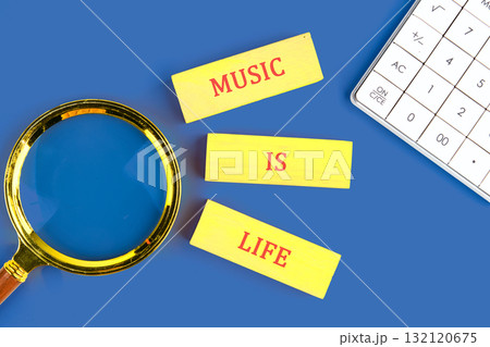 Bright yellow cards say music is life alongside a magnifying glass and calculator on a blue background, highlighting musics role in understanding our world and ourselves Bright yellow cards say music is life alongside a magnifying glass and calculator on a blue background, highlighting musics role in understanding our world and ourselves 132120675