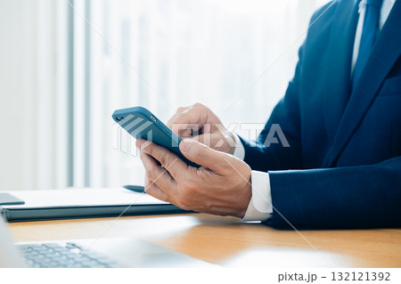 スマホを操作する男性の手元 132121392