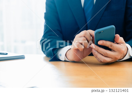 スマホを操作する男性の手元 スマホを操作する男性の手元 132121401