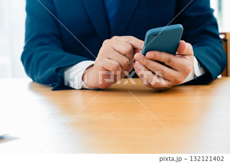 スマホを操作する男性の手元 132121402