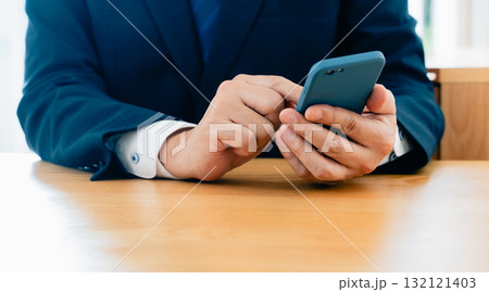 スマホを操作する男性の手元 132121403