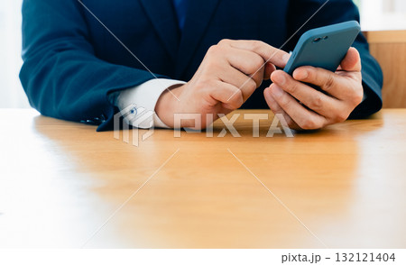 スマホを操作する男性の手元 132121404