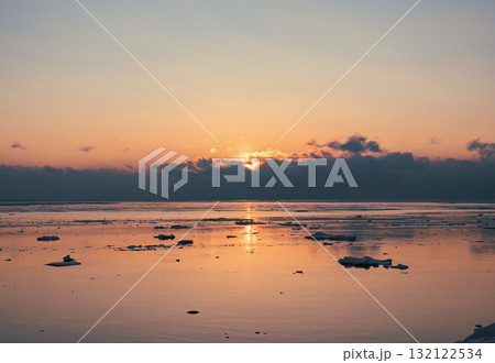 Sunrise over tranquil waters with ice floes reflecting soft light in an Arctic landscape Sunrise over tranquil waters with ice floes reflecting soft light in an Arctic landscape 132122534