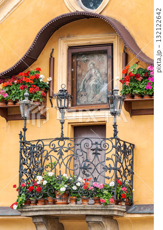 Ornate balcony with flowers and religious painting on yellow wall in Prague, Czech Republic Ornate balcony with flowers and religious painting on yellow wall in Prague, Czech Republic 132122642