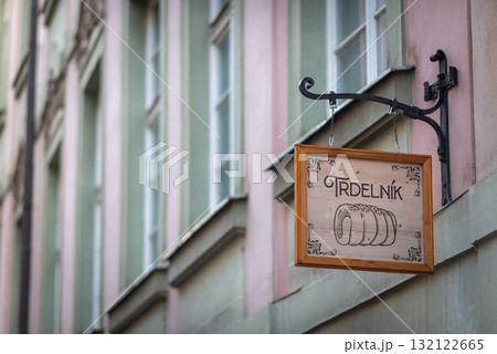 Wooden sign for a Trdelnik shop hanging on a facade in historic old town of Prague, Czech Republic Wooden sign for a Trdelnik shop hanging on a facade in historic old town of Prague, Czech Republic 132122665