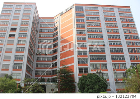 A tall, modern apartment building with a distinctive orange diagonal pattern on its facade, viewed from a low angle 132122704