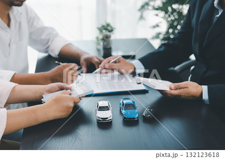Businessman explaining car loan agreement with calculator, customer discussing auto finance deal at office desk with toy car and document, concept of vehicle loan, insurance or car leasing. car loan. Businessman explaining car loan agreement with calculator, customer discussing auto finance deal at office desk with toy car and document, concept of vehicle loan, insurance or car leasing. car loan. 132123618