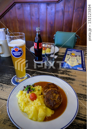 Traditional Bavarian meal with mashed potatoes, meat patties, and beer in a restaurant in Munich, Germany 132123894