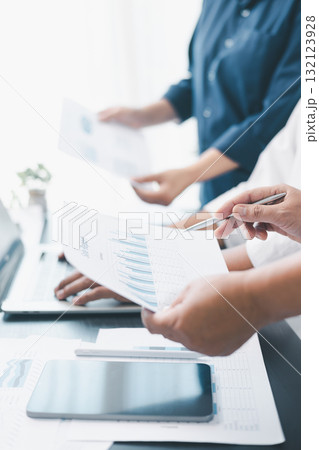 Business teamwork reviewing financial report with charts and graphs in modern office, colleagues discussing analysis, planning strategy, growth and corporate success with documents and technology. 132123928