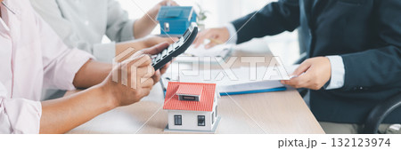 Panorama of mortgage calculation with house model, key, money, and calculator on desk, representing real estate loan agreement, property investment, financial planning and housing business success. Panorama of mortgage calculation with house model, key, money, and calculator on desk, representing real estate loan agreement, property investment, financial planning and housing business success. 132123974