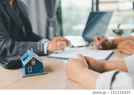Close up of business people signing loan agreement contract with pen and paperwork on desk, financial deal concept with laptop and calculator in modern office environment. loan agreement contract. 132124325