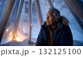 Indigenous elder telling stories inside a warm tent, frost on the outside wall. Life in permafrost conditions, climate change problems on the planet. Global warming 132125100