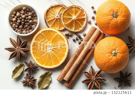 Fresh oranges, dried citrus slices, and spices arranged on a marble surface for culinary inspiration 132125611