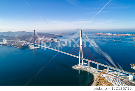 Stunning view of the Russky Bridge in Vladivostok with clear blue skies and tranquil waters. 132126719
