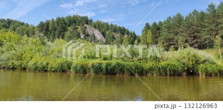 Scenic River View Serene Waters Flowing Through Lush Green Forest Under a Blue Sky, Nature Escape 132126963