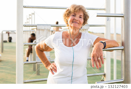 Mature sportswoman in workout station 132127403