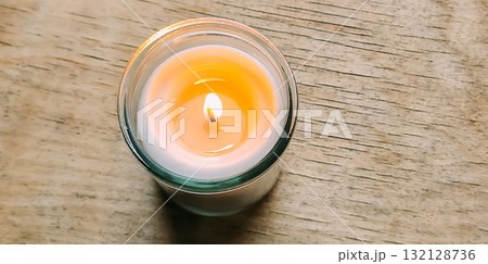 Warm flame in glass candle jar on cold winter day. 132128736