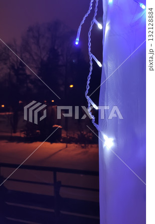 Window decorated with festive Christmas lights in cozy home interior. 132128884