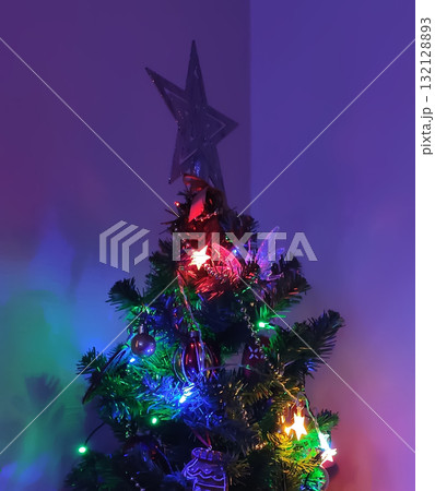 Close-up of decorated Christmas tree with glowing lights. Close-up of decorated Christmas tree with glowing lights. 132128893