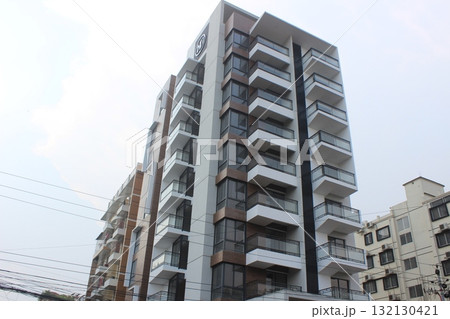 Modern residential building with multiple balconies and a contemporary facade, viewed from a low angle 132130421
