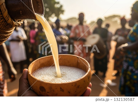 Pouring cameroonian matango a traditional palm wine at a village festival in the evening Pouring cameroonian matango a traditional palm wine at a village festival in the evening 132130587