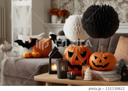 Festive Halloween decorations with carved pumpkins, lanterns, and themed ornaments in cozy living room Festive Halloween decorations with carved pumpkins, lanterns, and themed ornaments in cozy living room 132130622