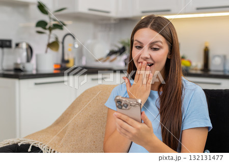 Young woman reads job offer on smartphone smiles covers mouth signs contract and sends accept reply 132131477