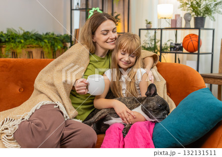 Mother daughter dog share tea and blanket relax together cozy rest hug smile comfort family evening Mother daughter dog share tea and blanket relax together cozy rest hug smile comfort family evening 132131511